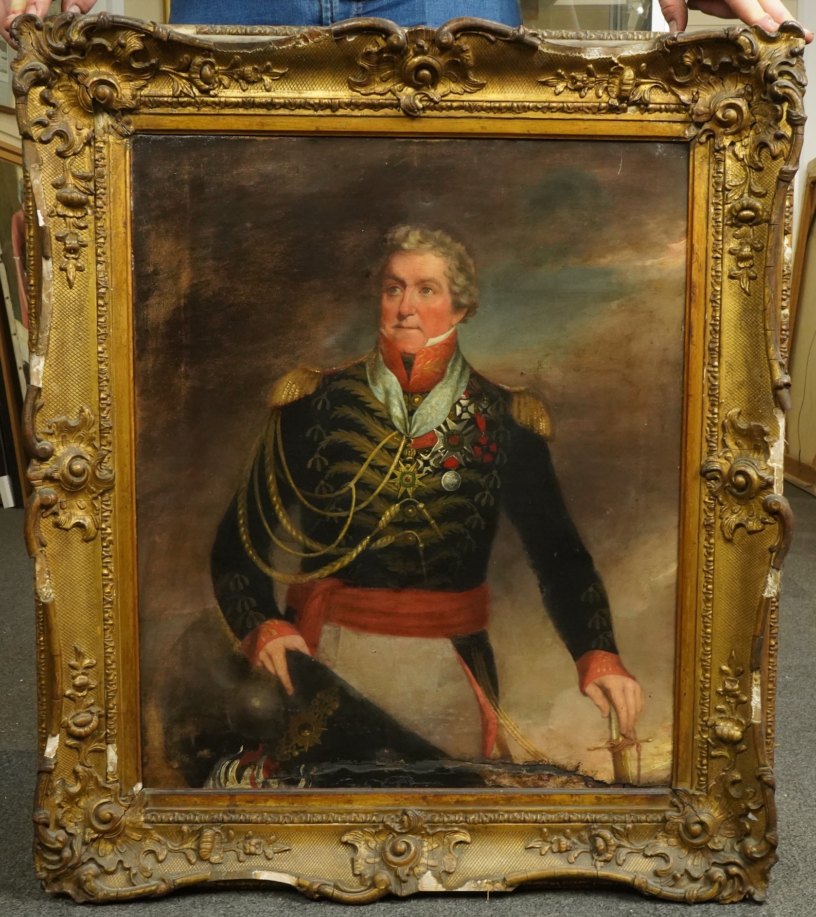 Early 19th Century English School, Three quarter length portrait of a Napoleonic General, standing with hat and sword in hand, clouds beyond, oil on canvas, 59 x 49cm